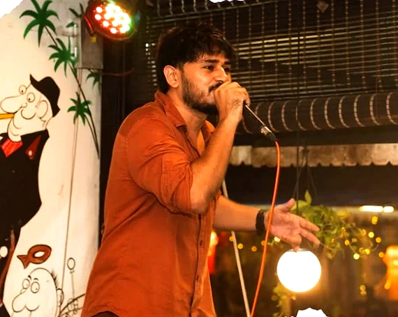 A singer mid-set on the terrace, string lights behind